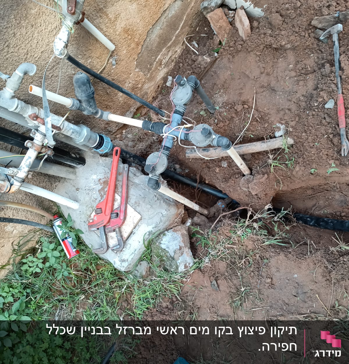 כלי עבודה וצינורות ליד חפירה באדמה